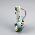 Hand-built decorative ceramic jar with organic, abstract forms and colourful details, made from earthenware and coloured earthenware, finished with a glossy transparent glaze. Created by artist Cíntia Coutinho, also known as Espirro, and photographed on a grey background.
