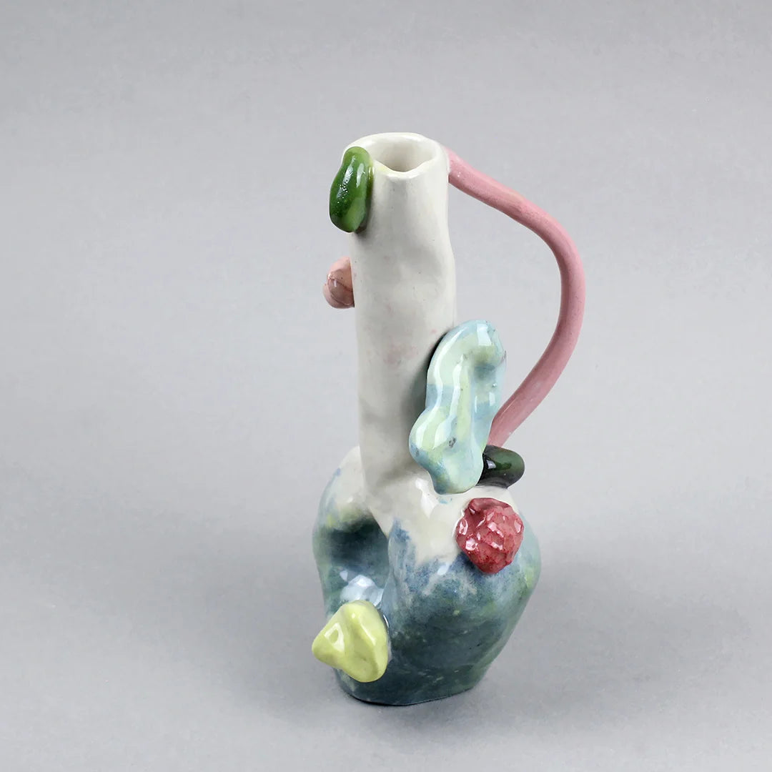 Hand-built decorative ceramic jar with organic, abstract forms and colourful details, made from earthenware and coloured earthenware, finished with a glossy transparent glaze. Created by artist Cíntia Coutinho, also known as Espirro, and photographed on a grey background.