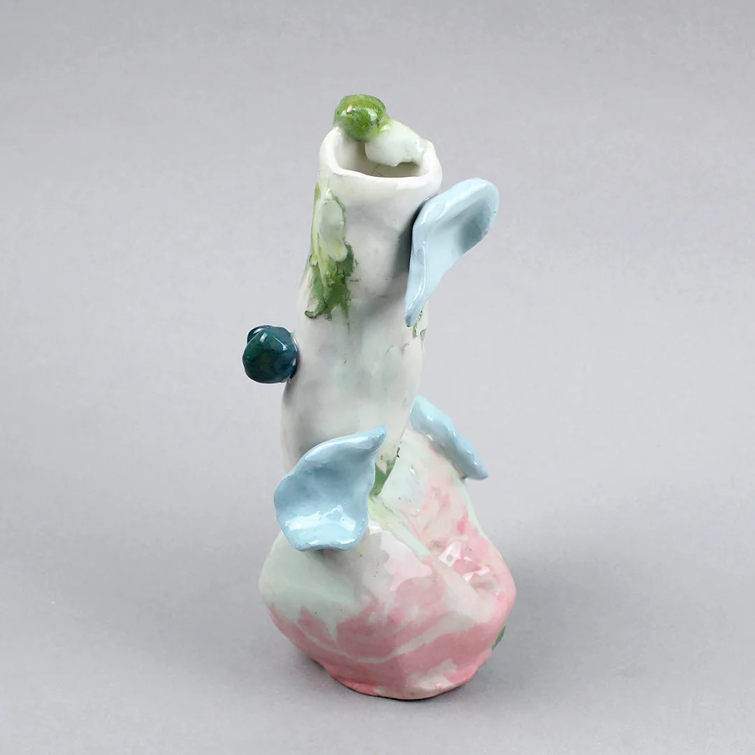 Hand-built decorative ceramic jar with organic, abstract forms and colourful details, made from earthenware and coloured earthenware, finished with a glossy transparent glaze. Created by artist Cíntia Coutinho, also known as Espirro, and photographed on a grey background.