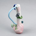 Hand-built decorative ceramic jar with organic, abstract forms and colourful details, made from earthenware and coloured earthenware, finished with a glossy transparent glaze. Created by artist Cíntia Coutinho, also known as Espirro, and photographed on a grey background.