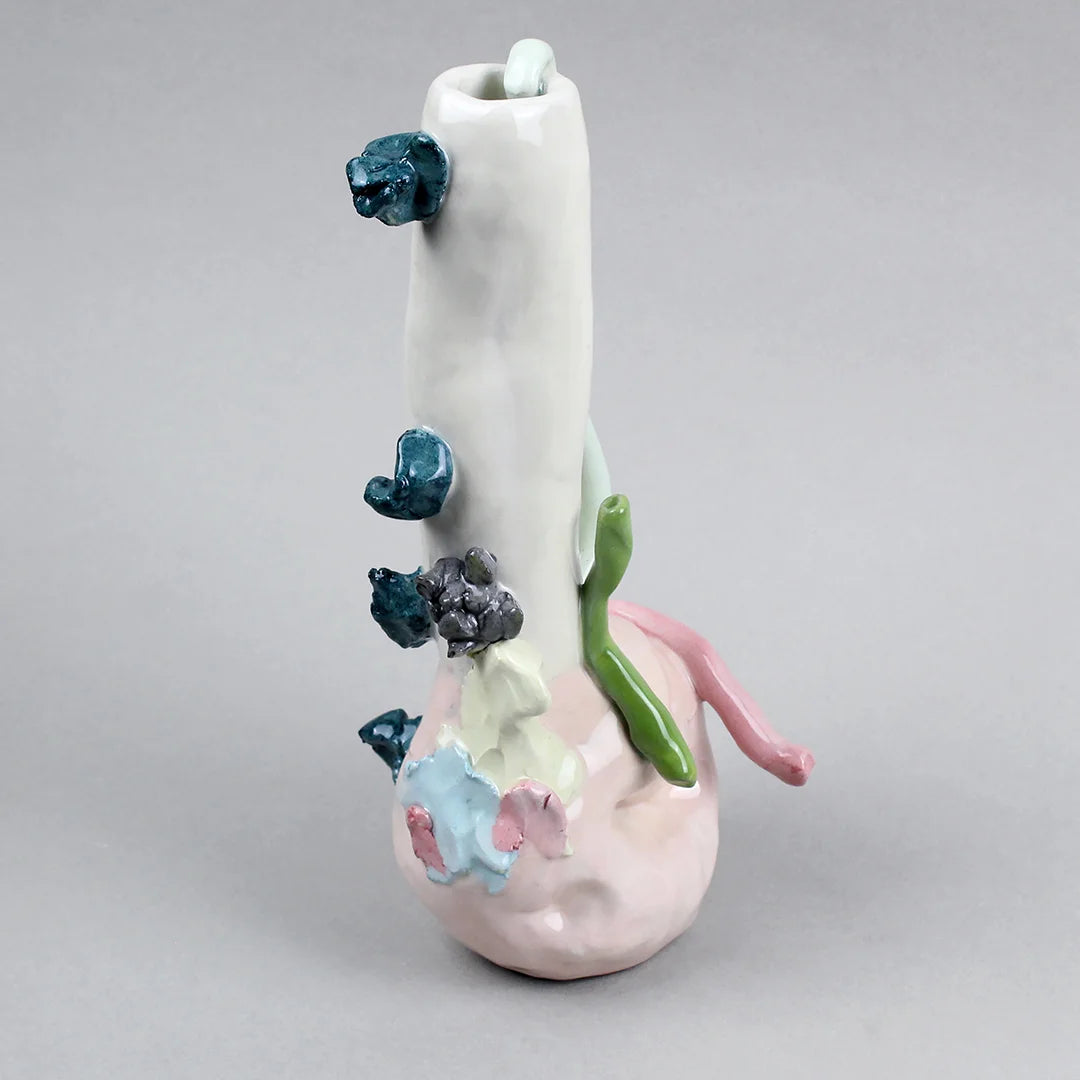 Hand-built decorative ceramic jar with organic, abstract forms and colourful details, made from earthenware and coloured earthenware, finished with a glossy transparent glaze. Created by artist Cíntia Coutinho, also known as Espirro, and photographed on a grey background.