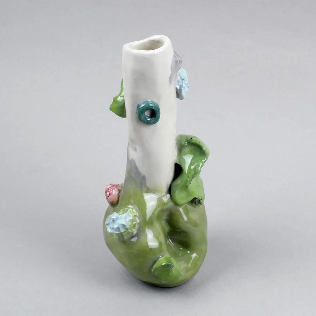 Hand-built decorative ceramic jar with organic, abstract forms and colourful details, made from earthenware and coloured earthenware, finished with a glossy transparent glaze. Created by artist Cíntia Coutinho, also known as Espirro, and photographed on a grey background.