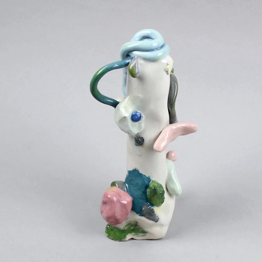 Hand-built decorative ceramic jar with organic, abstract forms and colourful details, made from earthenware and coloured earthenware, finished with a glossy transparent glaze. Created by artist Cíntia Coutinho, also known as Espirro, and photographed on a grey background.