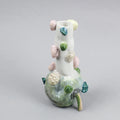 Hand-built decorative ceramic jar with organic, abstract forms and colourful details, made from earthenware and coloured earthenware, finished with a glossy transparent glaze. Created by artist Cíntia Coutinho, also known as Espirro, and photographed on a grey background.