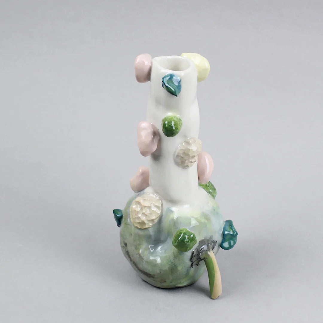 Hand-built decorative ceramic jar with organic, abstract forms and colourful details, made from earthenware and coloured earthenware, finished with a glossy transparent glaze. Created by artist Cíntia Coutinho, also known as Espirro, and photographed on a grey background.