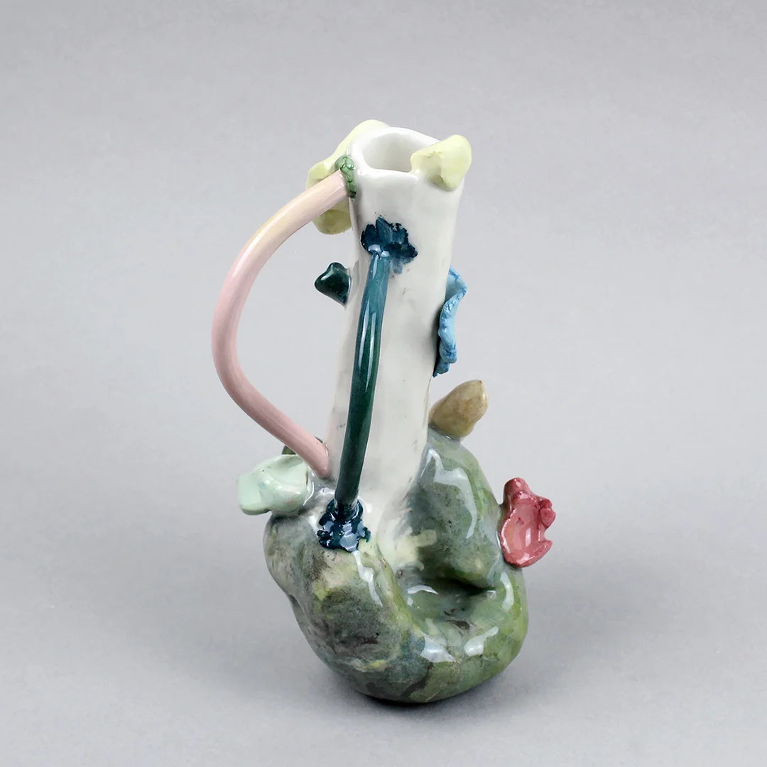 Hand-built decorative ceramic jar with organic, abstract forms and colourful details, made from earthenware and coloured earthenware, finished with a glossy transparent glaze. Created by artist Cíntia Coutinho, also known as Espirro, and photographed on a grey background.