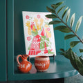 Decorative items including a colorful tile, orange pitcher, and mug on a teal surface with a plant.