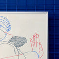 Detail of a manual screen print (50×70 cm) of an illustration of Tina Siuda showing two bodies embracing, drawn with fine linework on a white background. The figures extend almost to the edges of the paper, as if confined within its borders. The print is framed in a grey frame and hung on a Klein blue wall with matching blue metal bars.