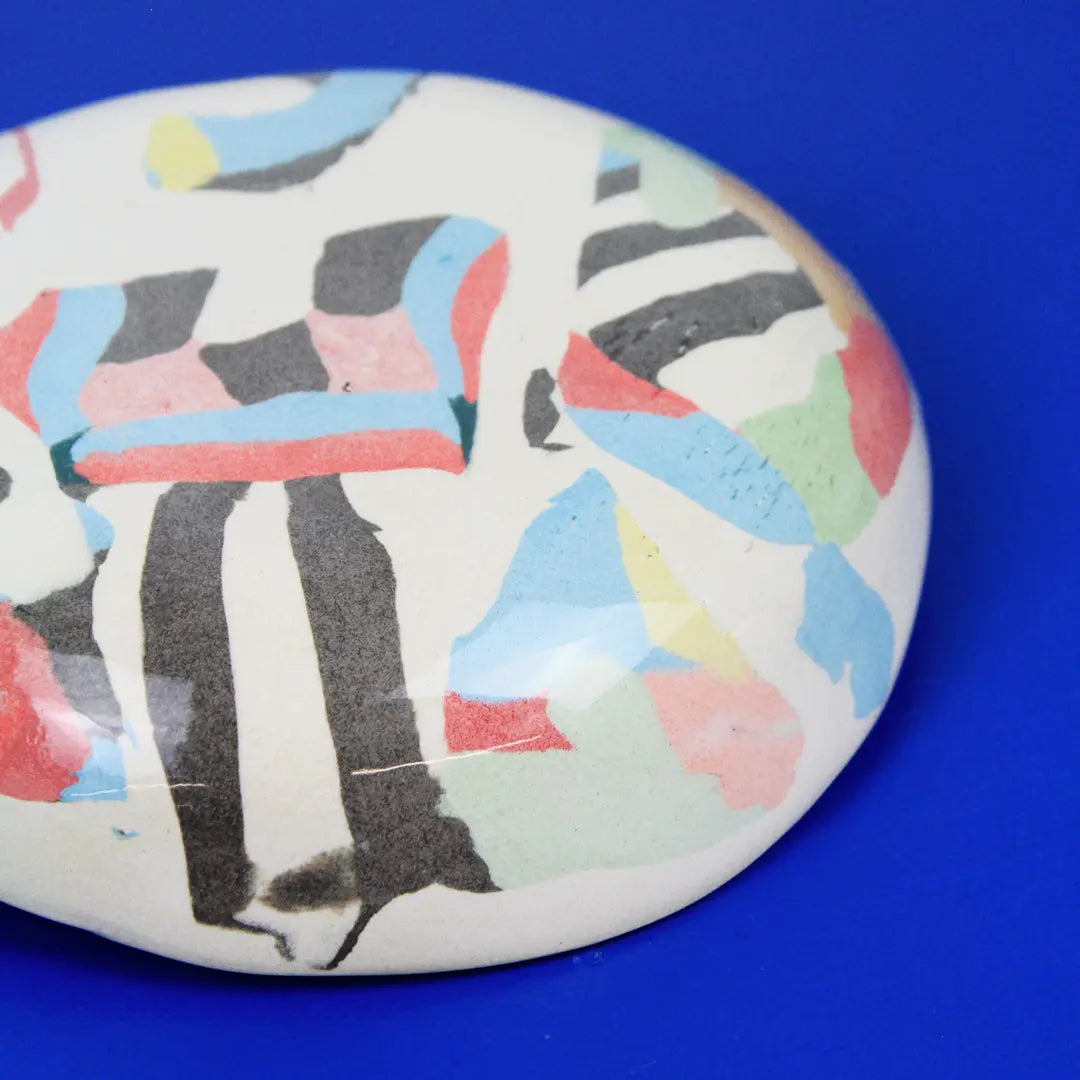 Hand-built decorative ceramic plate with organic, abstract forms and colourful details, made from earthenware and coloured earthenware, finished with a glossy transparent glaze. Created by artist Cíntia Coutinho, also known as Espirro.