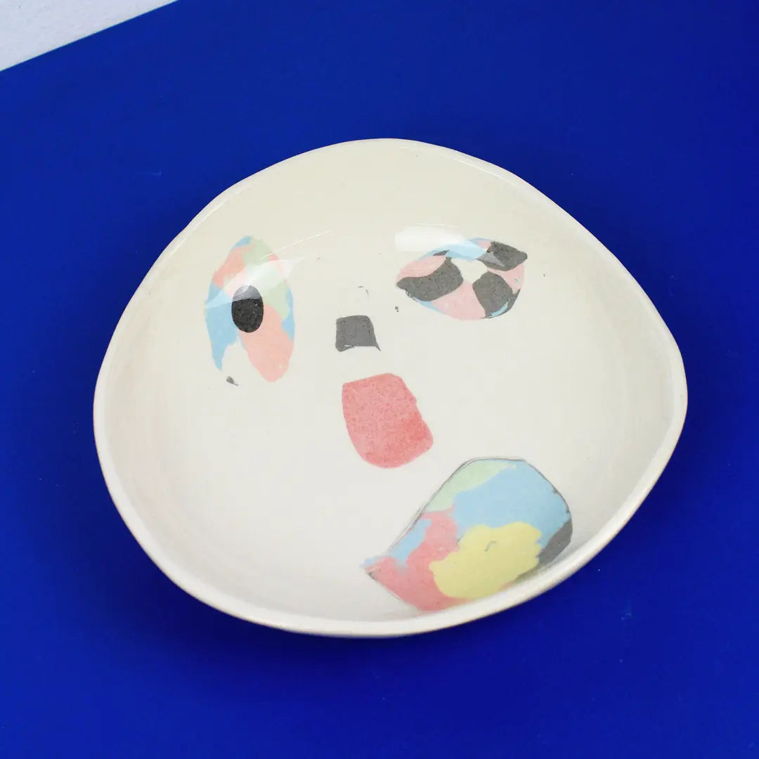 Hand-built decorative ceramic plate with organic, abstract forms and colourful details, made from earthenware and coloured earthenware, finished with a glossy transparent glaze. Created by artist Cíntia Coutinho, also known as Espirro.