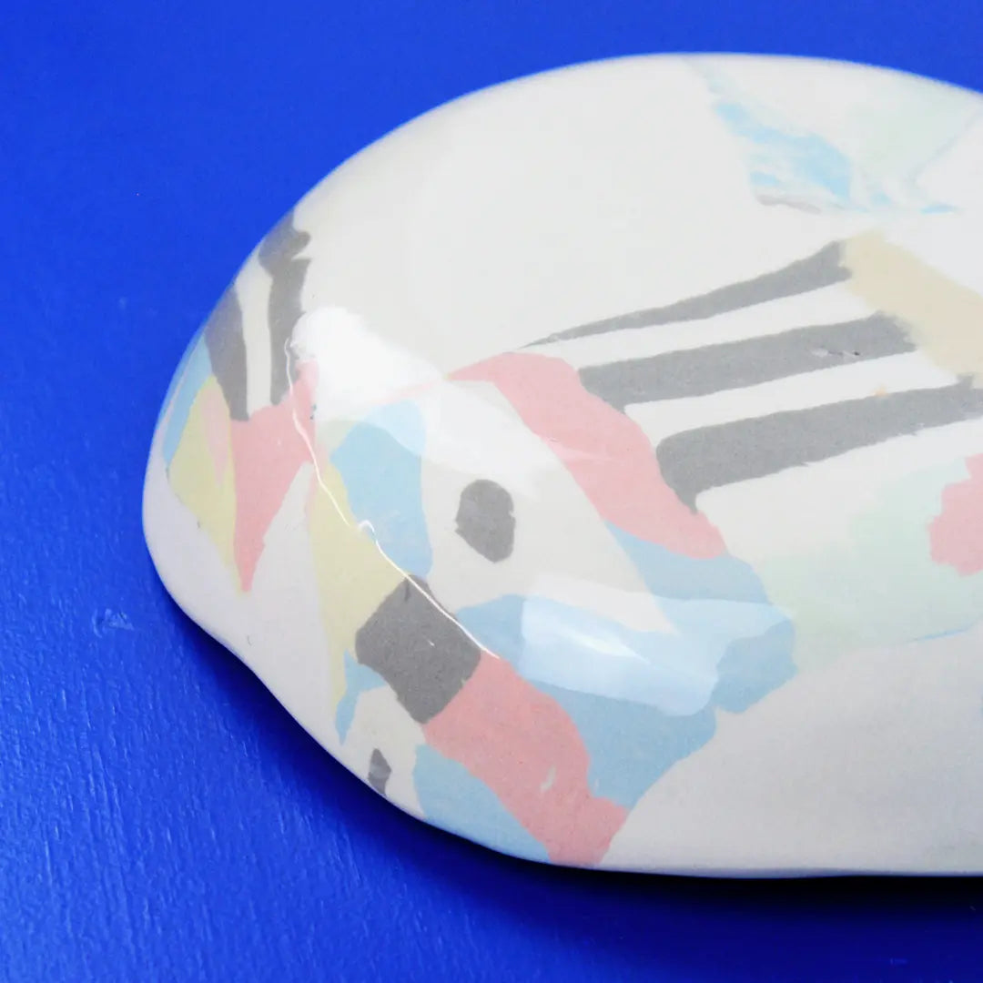 Hand-built decorative ceramic deep plate with organic, abstract forms and colourful details, made from earthenware and coloured earthenware, finished with a glossy transparent glaze. Created by artist Cíntia Coutinho, also known as Espirro.