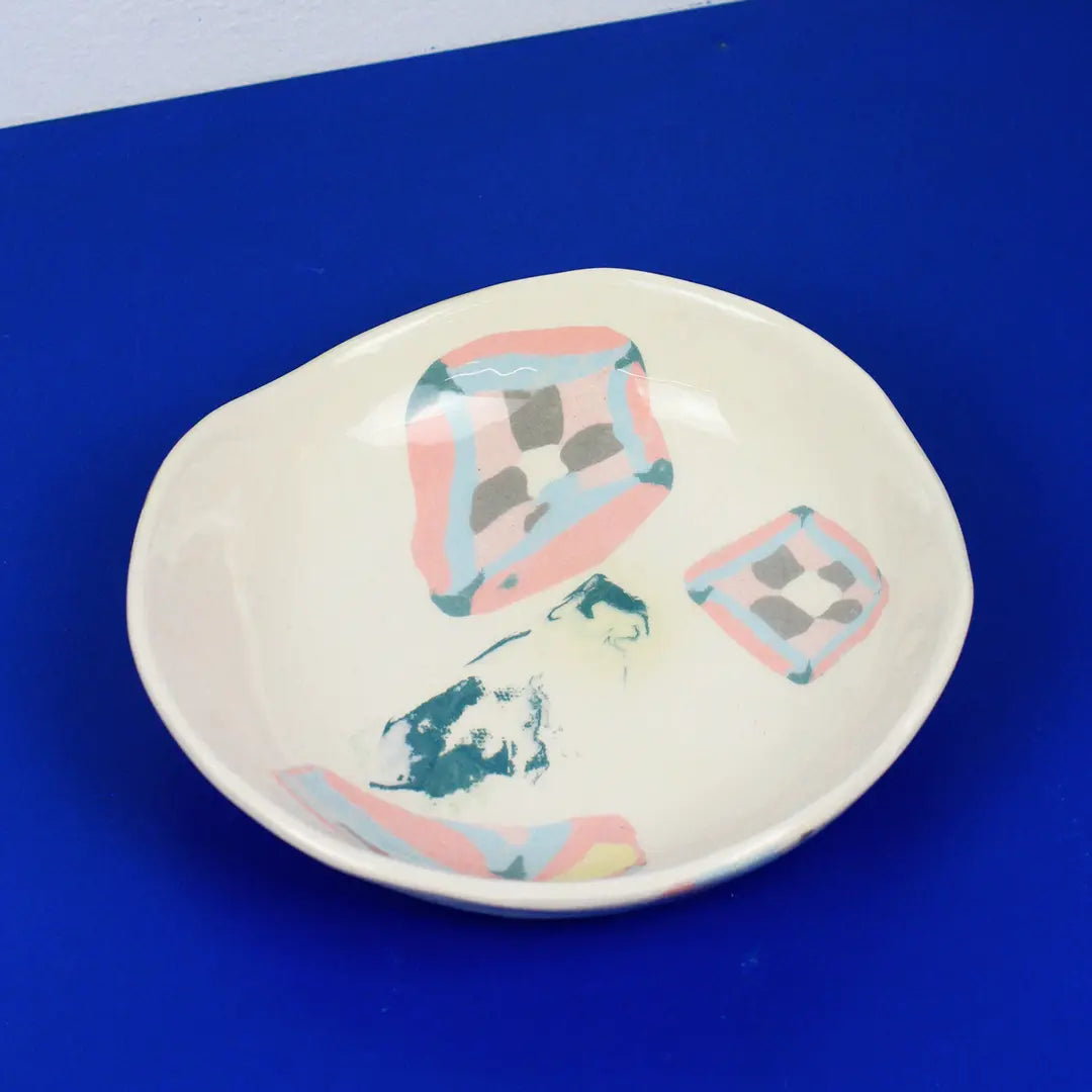 Hand-built decorative ceramic deep plate with organic, abstract forms and colourful details, made from earthenware and coloured earthenware, finished with a glossy transparent glaze. Created by artist Cíntia Coutinho, also known as Espirro.