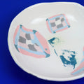 Hand-built decorative ceramic deep plate with organic, abstract forms and colourful details, made from earthenware and coloured earthenware, finished with a glossy transparent glaze. Created by artist Cíntia Coutinho, also known as Espirro.
