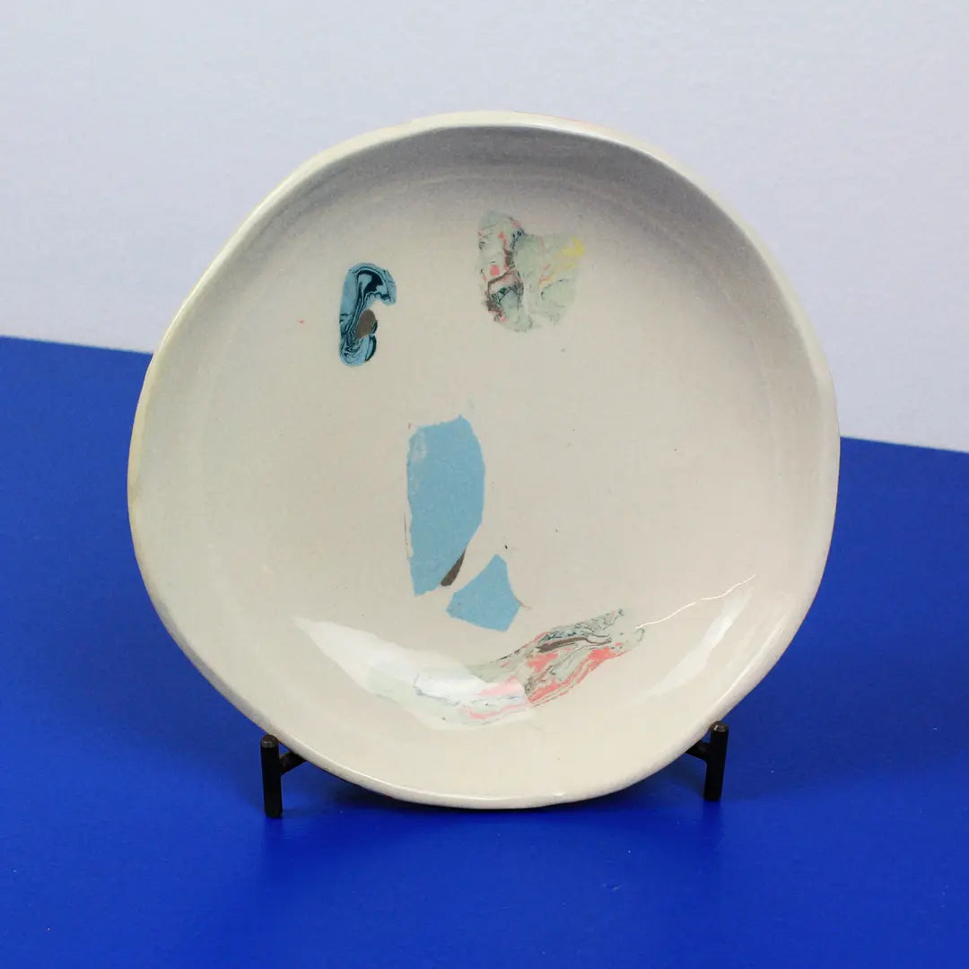 Hand-built decorative ceramic deep plate with organic, abstract forms and colourful details, made from earthenware and coloured earthenware, finished with a glossy transparent glaze. Created by artist Cíntia Coutinho, also known as Espirro.