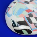 Hand-built decorative ceramic deep plate with organic, abstract forms and colourful details, made from earthenware and coloured earthenware, finished with a glossy transparent glaze. Created by artist Cíntia Coutinho, also known as Espirro.