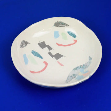 Hand-built decorative ceramic deep plate with organic, abstract forms and colourful details, made from earthenware and coloured earthenware, finished with a glossy transparent glaze. Created by artist Cíntia Coutinho, also known as Espirro.