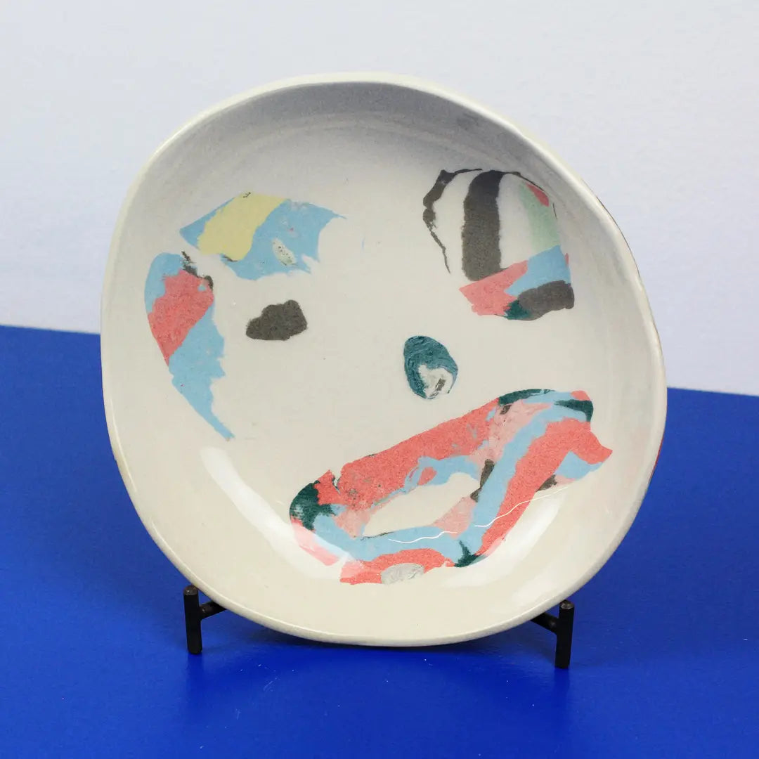 Hand-built decorative ceramic plate with organic, abstract forms and colourful details, made from earthenware and coloured earthenware, finished with a glossy transparent glaze. Created by artist Cíntia Coutinho, also known as Espirro.