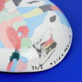Hand-built decorative ceramic deep plate with organic, abstract forms and colourful details, made from earthenware and coloured earthenware, finished with a glossy transparent glaze. Created by artist Cíntia Coutinho, also known as Espirro.