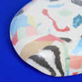 Hand-built decorative ceramic deep plate with organic, abstract forms and colourful details, made from earthenware and coloured earthenware, finished with a glossy transparent glaze. Created by artist Cíntia Coutinho, also known as Espirro.