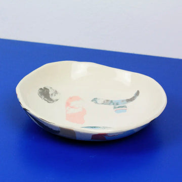 Hand-built decorative ceramic deep plate with organic, abstract forms and colourful details, made from earthenware and coloured earthenware, finished with a glossy transparent glaze. Created by artist Cíntia Coutinho, also known as Espirro.