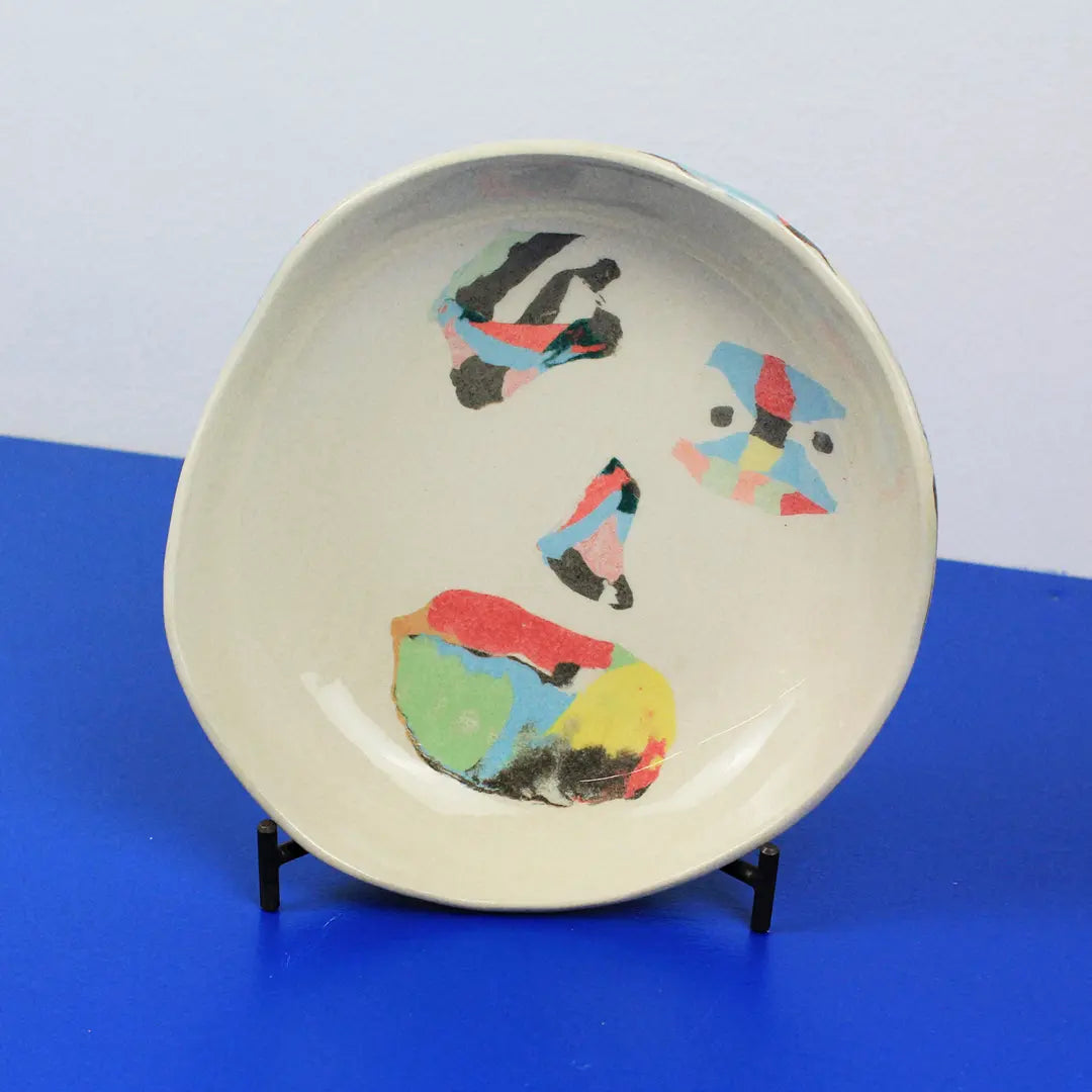 Hand-built decorative ceramic deep plate with organic, abstract forms and colourful details, made from earthenware and coloured earthenware, finished with a glossy transparent glaze. Created by artist Cíntia Coutinho, also known as Espirro.