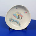 Hand-built decorative ceramic deep plate with organic, abstract forms and colourful details, made from earthenware and coloured earthenware, finished with a glossy transparent glaze. Created by artist Cíntia Coutinho, also known as Espirro.