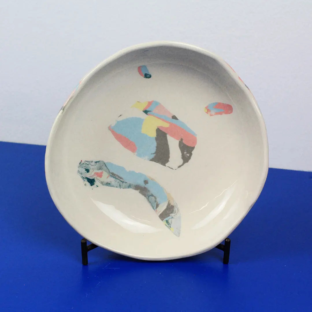 Hand-built decorative ceramic deep plate with organic, abstract forms and colourful details, made from earthenware and coloured earthenware, finished with a glossy transparent glaze. Created by artist Cíntia Coutinho, also known as Espirro.