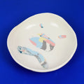 Hand-built decorative ceramic deep plate with organic, abstract forms and colourful details, made from earthenware and coloured earthenware, finished with a glossy transparent glaze. Created by artist Cíntia Coutinho, also known as Espirro.