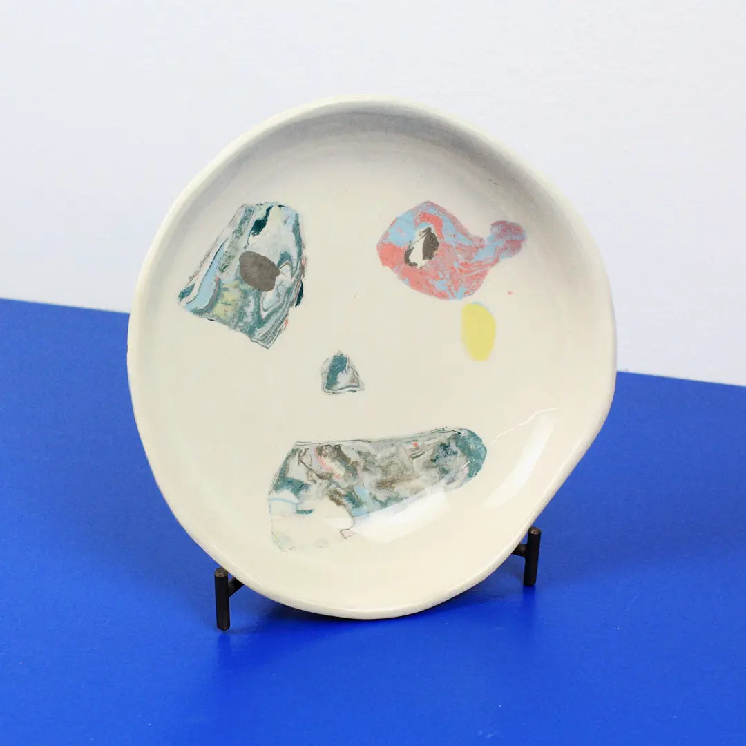 Hand-built decorative ceramic deep plate with organic, abstract forms and colourful details, made from earthenware and coloured earthenware, finished with a glossy transparent glaze. Created by artist Cíntia Coutinho, also known as Espirro.