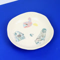 Hand-built decorative ceramic deep plate with organic, abstract forms and colourful details, made from earthenware and coloured earthenware, finished with a glossy transparent glaze. Created by artist Cíntia Coutinho, also known as Espirro.