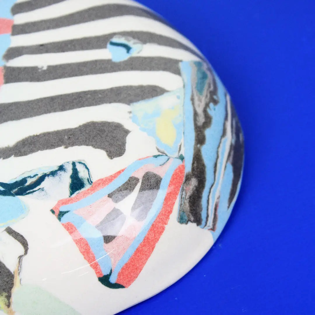 Hand-built decorative ceramic deep plate with organic, abstract forms and colourful details, made from earthenware and coloured earthenware, finished with a glossy transparent glaze. Created by artist Cíntia Coutinho, also known as Espirro.