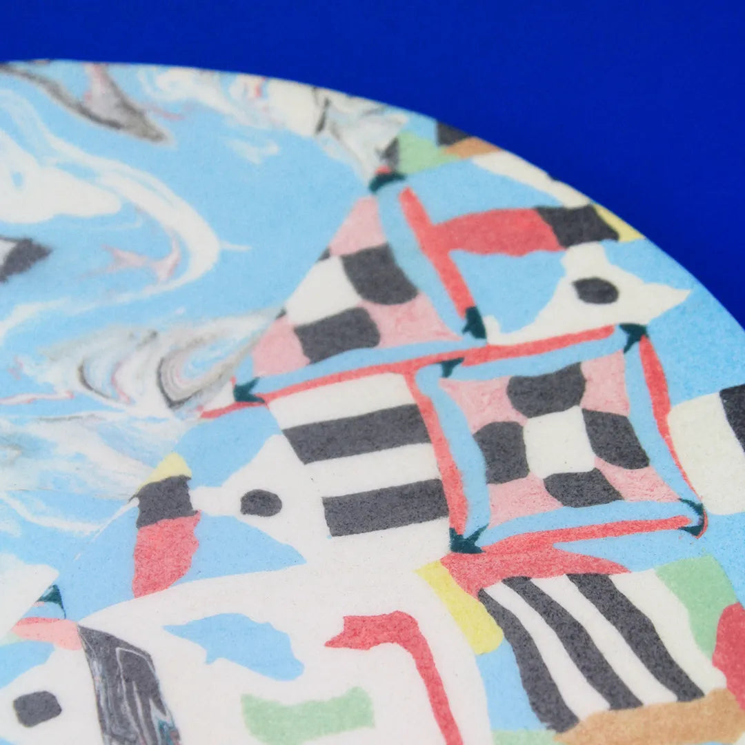 Hand-built decorative ceramic flat plate with organic, abstract forms and colourful details, made from earthenware and coloured earthenware, finished with a glossy transparent glaze. Created by artist Cíntia Coutinho, also known as Espirro.