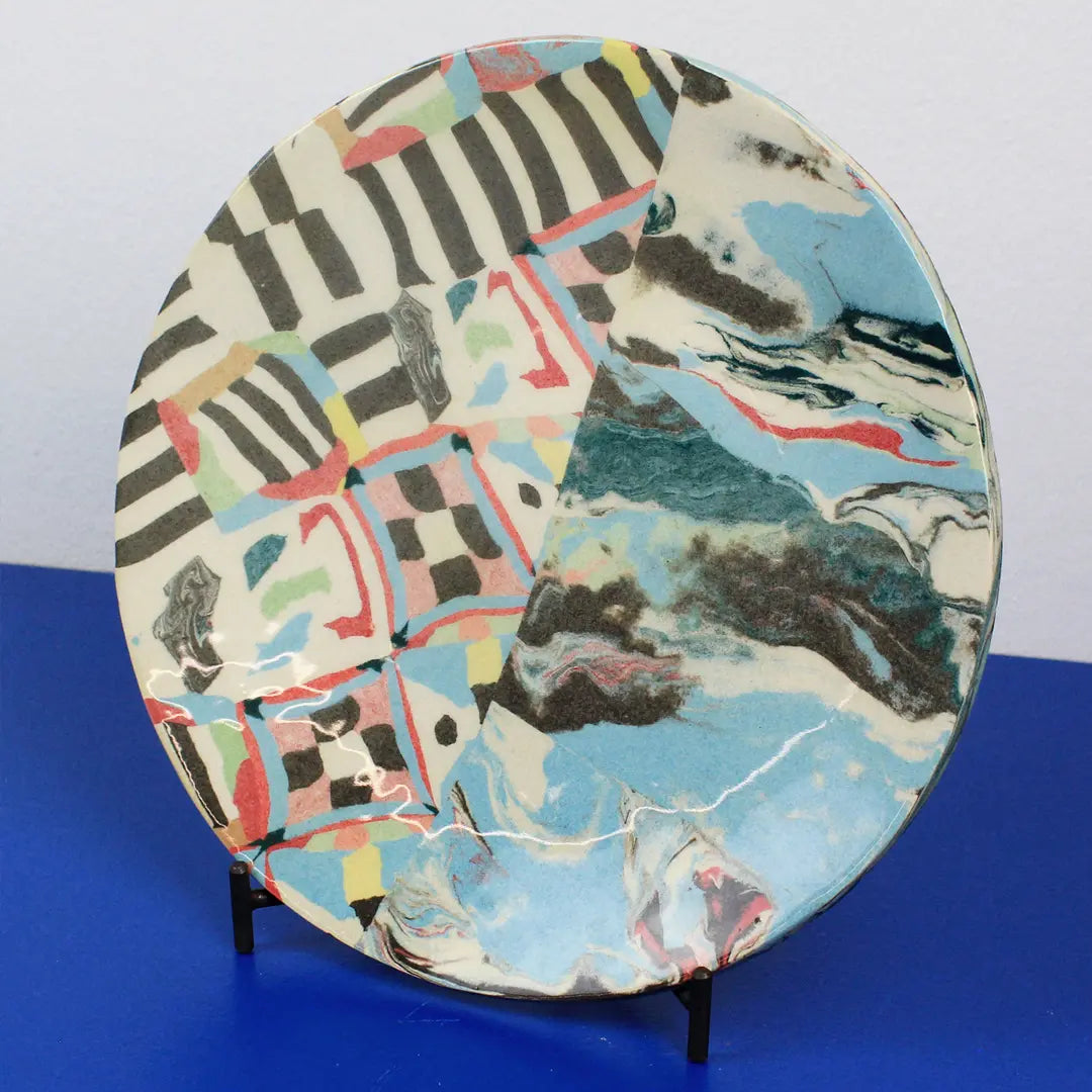 Hand-built decorative ceramic plate with organic, abstract forms and colourful details, made from earthenware and coloured earthenware, finished with a glossy transparent glaze. Created by artist Cíntia Coutinho, also known as Espirro.