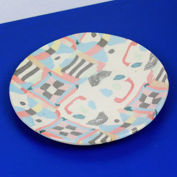Hand-built decorative ceramic plate with organic, abstract forms and colourful details, made from earthenware and coloured earthenware, finished with a glossy transparent glaze. Created by artist Cíntia Coutinho, also known as Espirro.