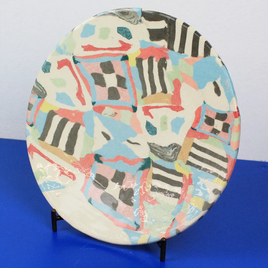 Hand-built decorative ceramic plate with organic, abstract forms and colourful details, made from earthenware and coloured earthenware, finished with a glossy transparent glaze. Created by artist Cíntia Coutinho, also known as Espirro.