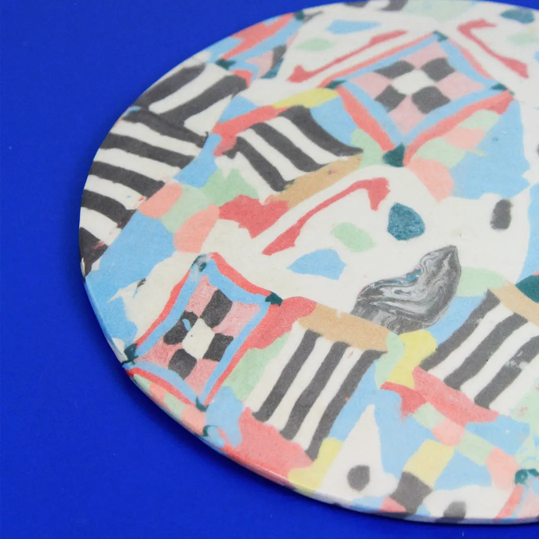 Hand-built decorative ceramic plate with organic, abstract forms and colourful details, made from earthenware and coloured earthenware, finished with a glossy transparent glaze. Created by artist Cíntia Coutinho, also known as Espirro.