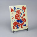 Screen-printed tile with an Artwork from Gonçalo Duarte, with blue and red colors, on a stand against a gray background