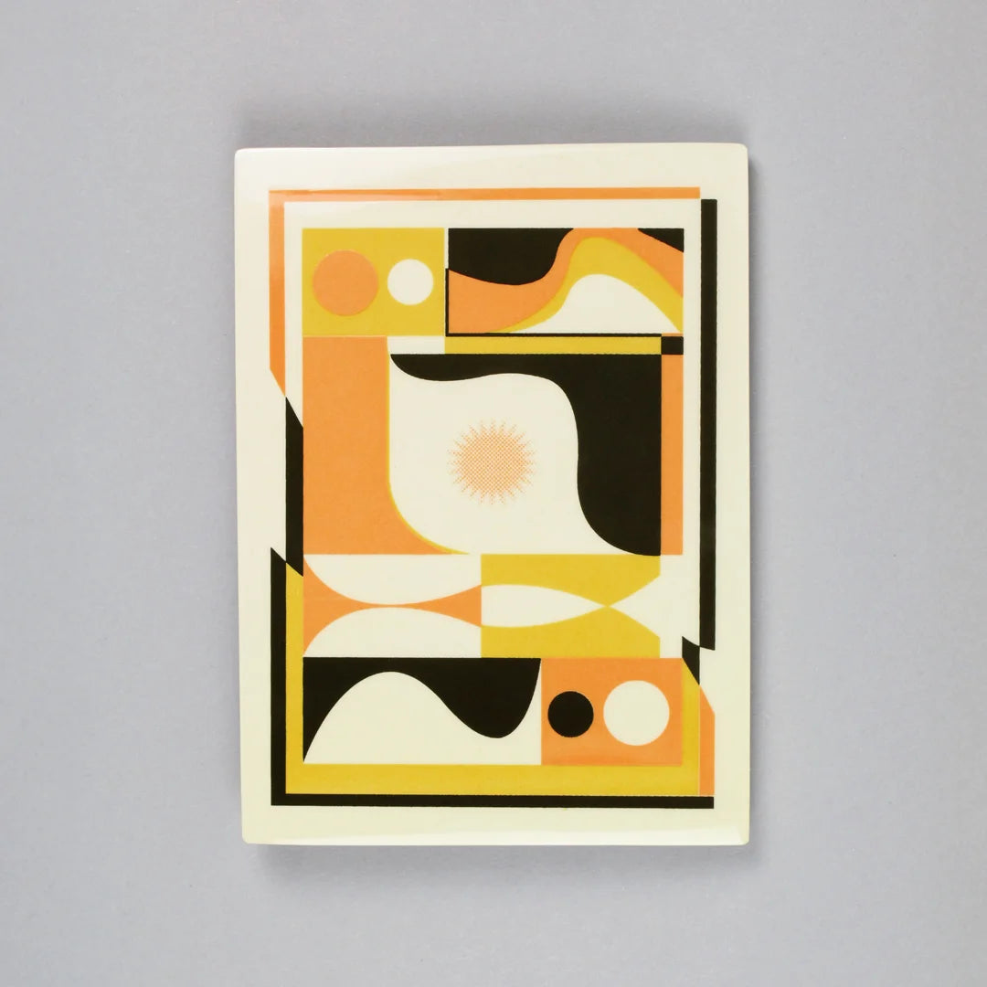 Screen-printed tile with an Artwork from Luís Silva, with orange, yellow and black colors, on a stand against a gray background